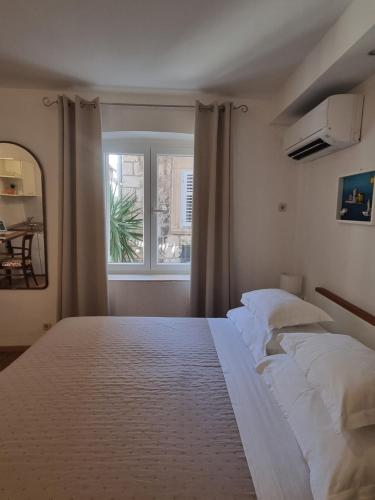 a bedroom with a large bed and a window at Studio Riva in Hvar