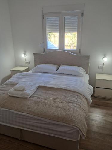 a large bed in a bedroom with two windows at Apartment Nikola R in Žabljak