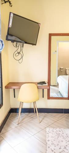 a room with a chair and a mirror at Wenyeji Inn Hotel Moshi in Moshi