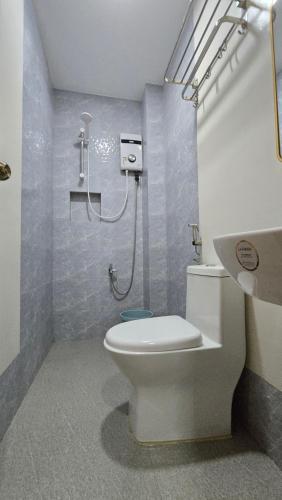 a bathroom with a shower and a toilet and a sink at La Casa Princesa Inn in Puerto Princesa City