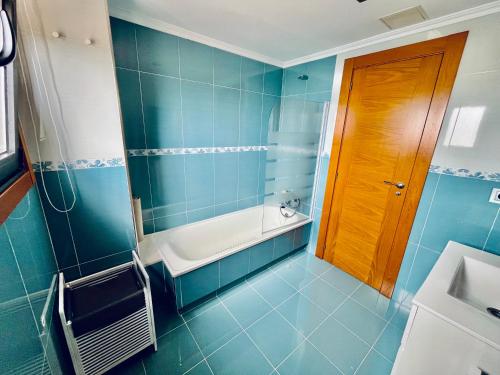 a blue bathroom with a tub and a sink at Casa do Prado in Pontevedra