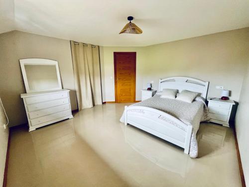 a bedroom with a bed and a dresser and a mirror at Casa do Prado in Pontevedra