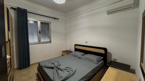a bedroom with a bed and a window at David’s apartments in Hamallë