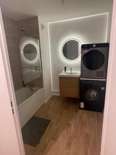 a bathroom with a sink and a microwave at Edna House in Montigny-lès-Cormeilles