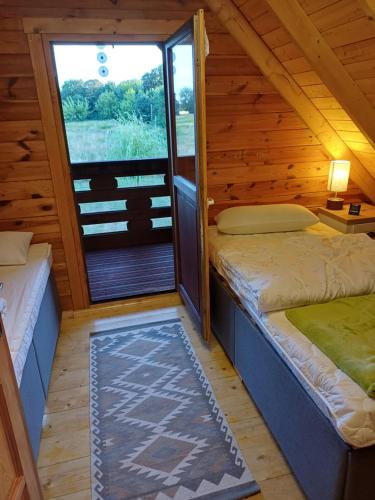 ein Zimmer mit zwei Betten und einem Fenster in einer Hütte in der Unterkunft Auszeit im Oderbruch in Letschin