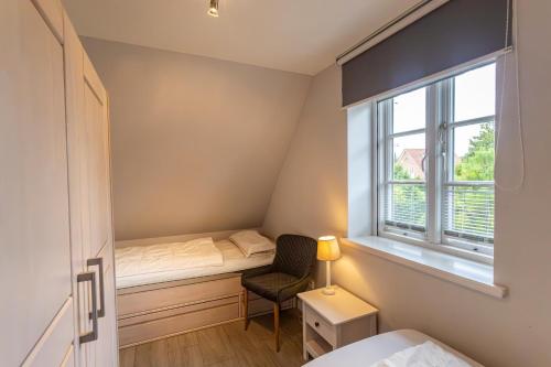 a small bedroom with a bed and a window at Doppelhaushälfte OHANA in Böhl