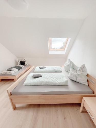 two beds in a white room with a window at Ferienwohnung am Klöckhof in Marktoberdorf
