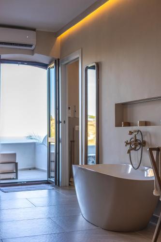 a large white tub in a bathroom with an open door at Porta di Savoca in Savoca