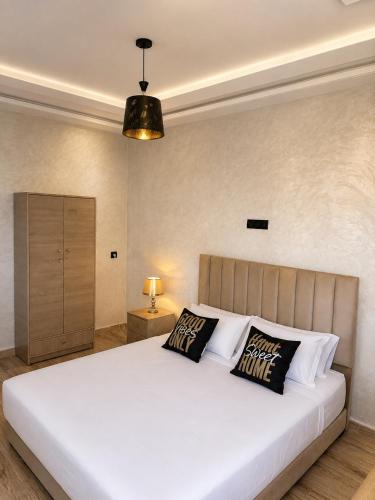 a bedroom with a large white bed with two pillows at Appart Hidaya in Fez