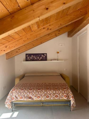 a bedroom with a bed in a room with wooden ceilings at Ecoloft Radici in Poderia