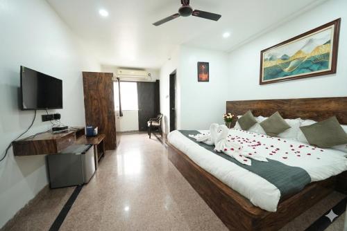 a bedroom with a bed and a flat screen tv at Hotel Ratan International in Raipur