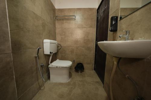 a bathroom with a toilet and a sink at Hotel Ratan International in Raipur