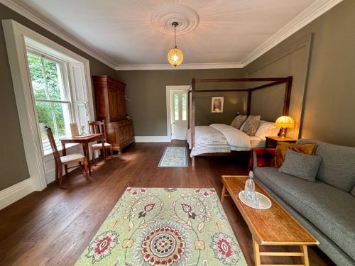 a living room with a bed and a couch at Blackhill Woods Retreat in Abbeyleix