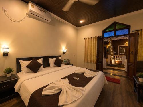 a bedroom with a bed and a air conditioner at Palm Escape Beach Resort in Baga