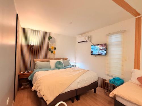 a bedroom with a bed and a tv on the wall at Estadía con opción jacuzzi Villa Alemana in Villa Alemana