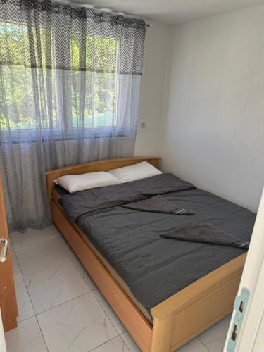 a bed in a small room with a window at Sarajevo Corner in Gladno Polje