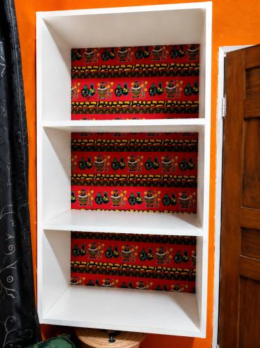 a white book shelf with three red ties on it at Naisi spur in Zomba