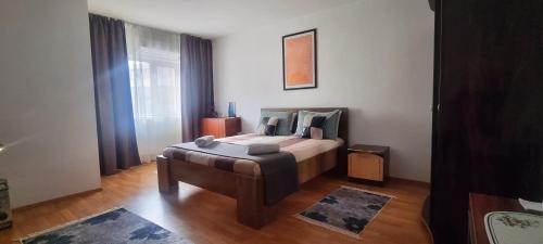 a bedroom with a bed and a chair in it at Sergio City Apartments in Craiova