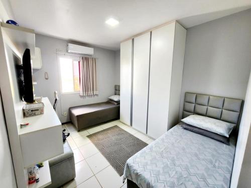 a small room with a bed and a television at Apartamento Park Vinhais in São Luís