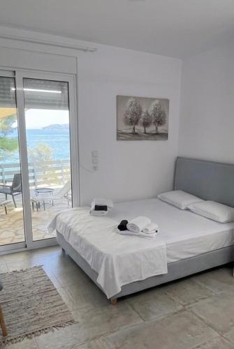 a bedroom with a bed and a view of the ocean at Sadova Messinia Pearl Cozy Seafront House in Avía