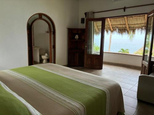 a bedroom with a bed with a view of the ocean at Bungalows Lydia San Pancho in San Francisco