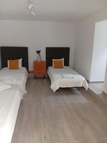 a room with two beds and a wooden floor at Carregado Groundfloor in Carregado