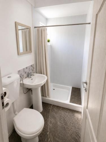 a white bathroom with a toilet and a sink at Casute tip A costinesti in Costinesti