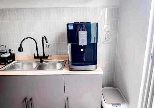 a kitchen with a coffee maker on a counter next to a sink at Gamuda Cove 4BR SplashMania in Banting