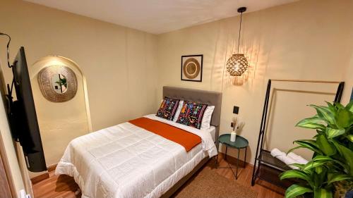 a bedroom with a bed and a potted plant at Nam Hotel Boutique Medellin in Medellín