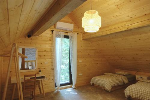 a bedroom in a log cabin with two beds at BOHO Forest Retreat in Novo Mesto
