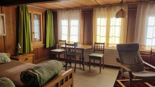 a bedroom with a table and chairs and a dining room at bed and breakfast Liechti in Wattenwil