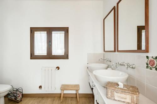 a white bathroom with two sinks and a mirror at Casa Huertas del Palmar in Teror