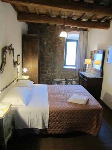 a bedroom with a bed and a window and a television at Principessa in Panicale
