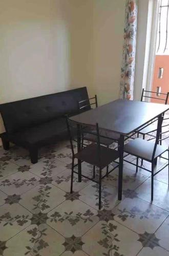 a dining room with a table and chairs and a bench at Studio Cosy Mde Comores 