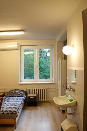 a bedroom with a bed and a sink and a window at Helska Ostoya in Hel