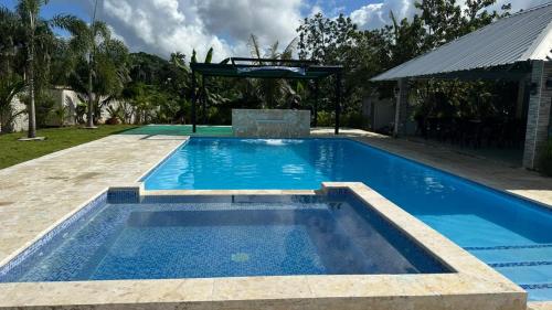 a large blue swimming pool with a pergola at The Resident 