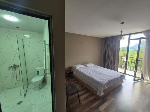 a bedroom with a bed and a bathroom with a shower at Villa Okatse in Zeda-Gordi