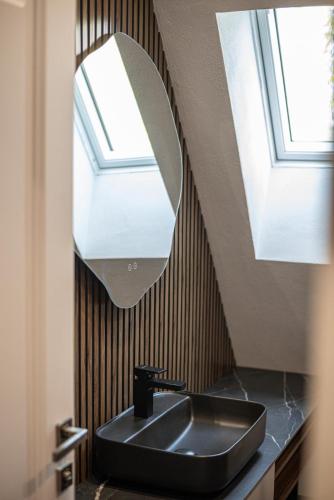 a bathroom with a black sink and a mirror at AVA Chalet with Jacuzzi in Sinaia