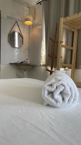 a bath tub with a white towel on a bed at Pousada Mangai in João Pessoa