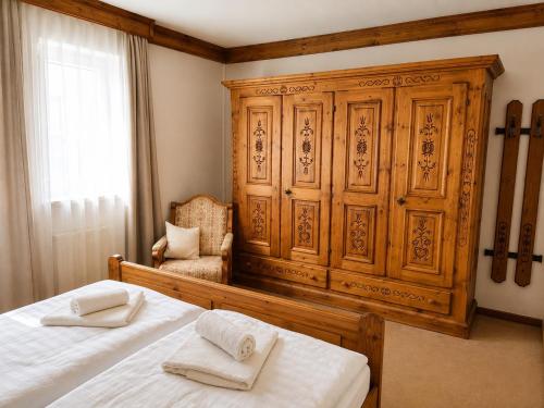 a bedroom with a wooden cabinet and a bed with two towels at Kurpark Suite in Bad Rodach