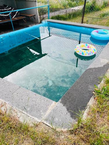 a swimming pool with a net and two frisbees at Gariks house in Lichkʼ