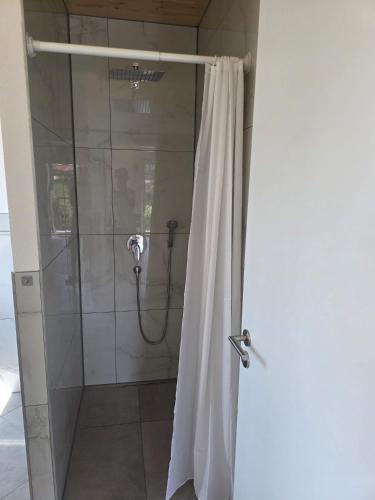 a shower with a shower curtain in a bathroom at Little Break 2, Nähe Legoland in Röfingen