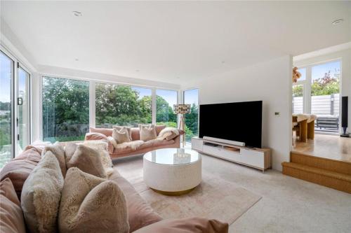 a living room with a couch and a tv at Mincarlo House in St Austell