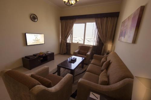 a living room with a couch and chairs and a table at Ivory Grand Hotel Apartments in Dubai