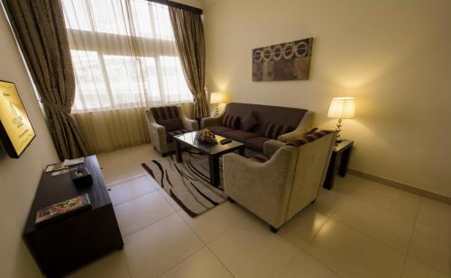a living room with a couch and a table at Ivory Grand Hotel Apartments in Dubai