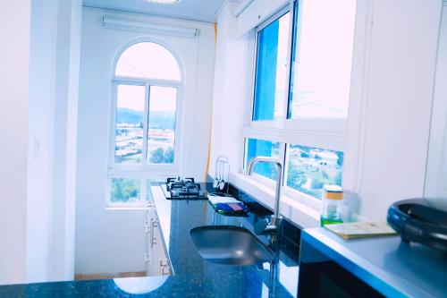 a bathroom with two sinks and two windows at Apartamento THEMIS Tocancipa in Bemposta