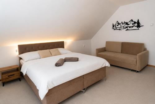 a bedroom with a large bed and a chair at Apartmánový dom Adriana in Zuberec
