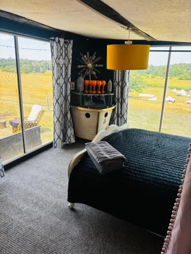 a bedroom with a bed with a view of a field at Farmstay cabin firepit & activities in Hertford
