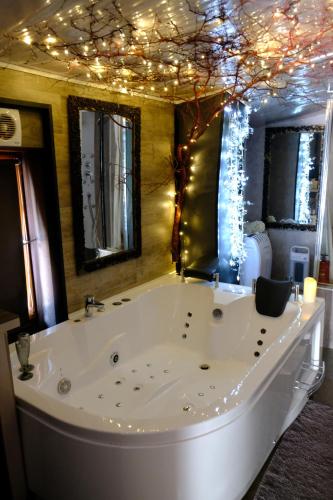 a large white tub with christmas lights in a bathroom at Lyon Campagne in Rontalon
