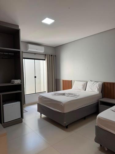 a bedroom with a large bed and a window at Rosmarry Hotel in Colinas do Tocantins